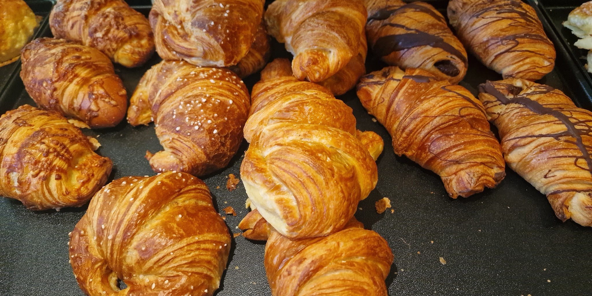 Frische Croissants und Schokoladencroissants auf einem Blech